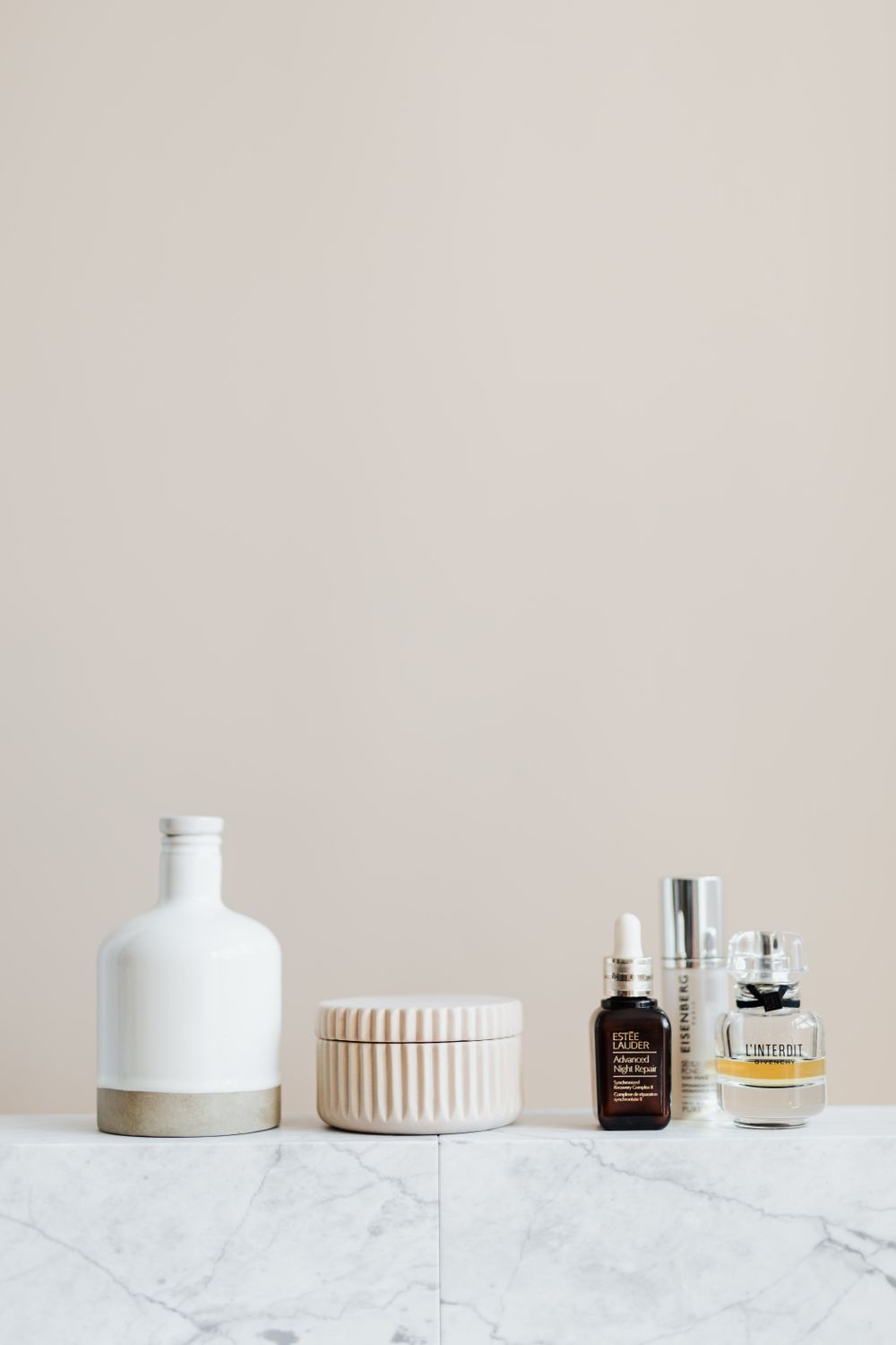 Cosmétiques et lumière naturelle sur une étagère en marbre